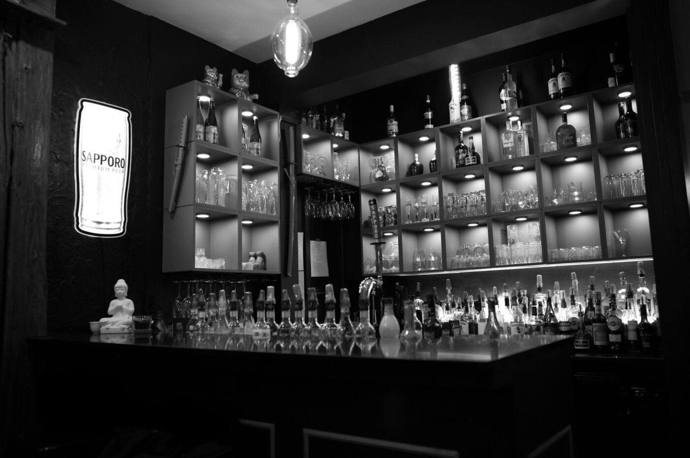 The bar and its backlit bottle shelves