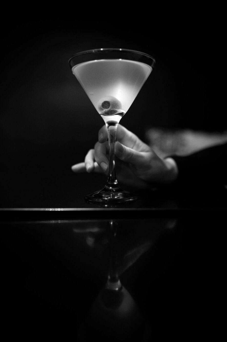 A martini raised in the half-light